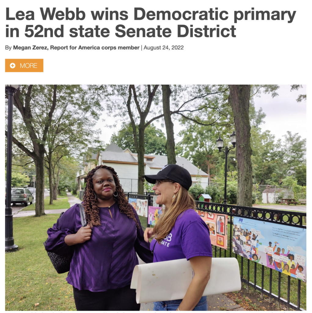 Screenshot of article about Lea Webb with photo of Lea and Jess Wisneski on sidewalk near a park. Headline reads: "Lea Webb wins Democratic primary in 52nd state Senate District."