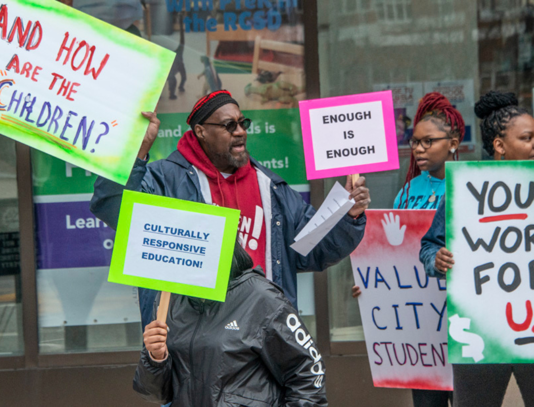 Citizen Action members at a Rochester Education Rally holding signs.